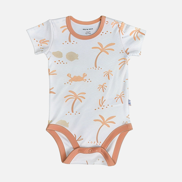 Baby onesie with palm tree and shell pattern on a white background