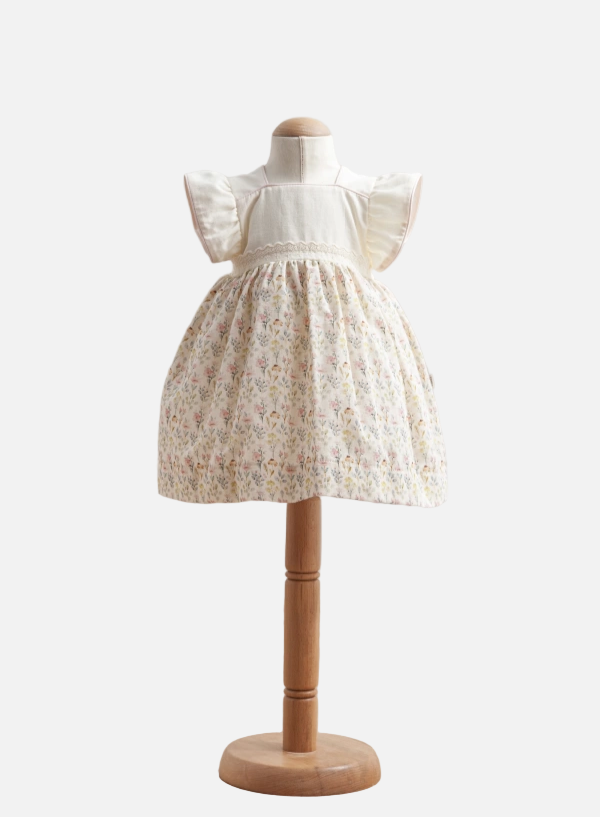 White lace dress on a mannequin with a wooden base against a white background