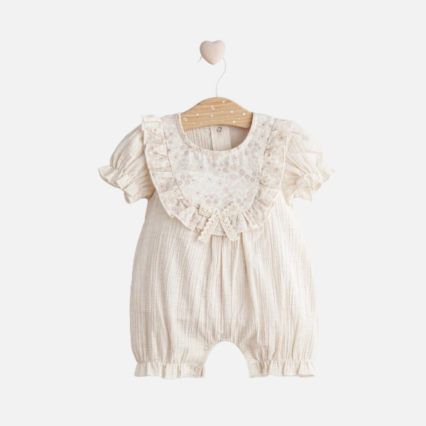 Baby romper with lace details on a hanger against a white background
