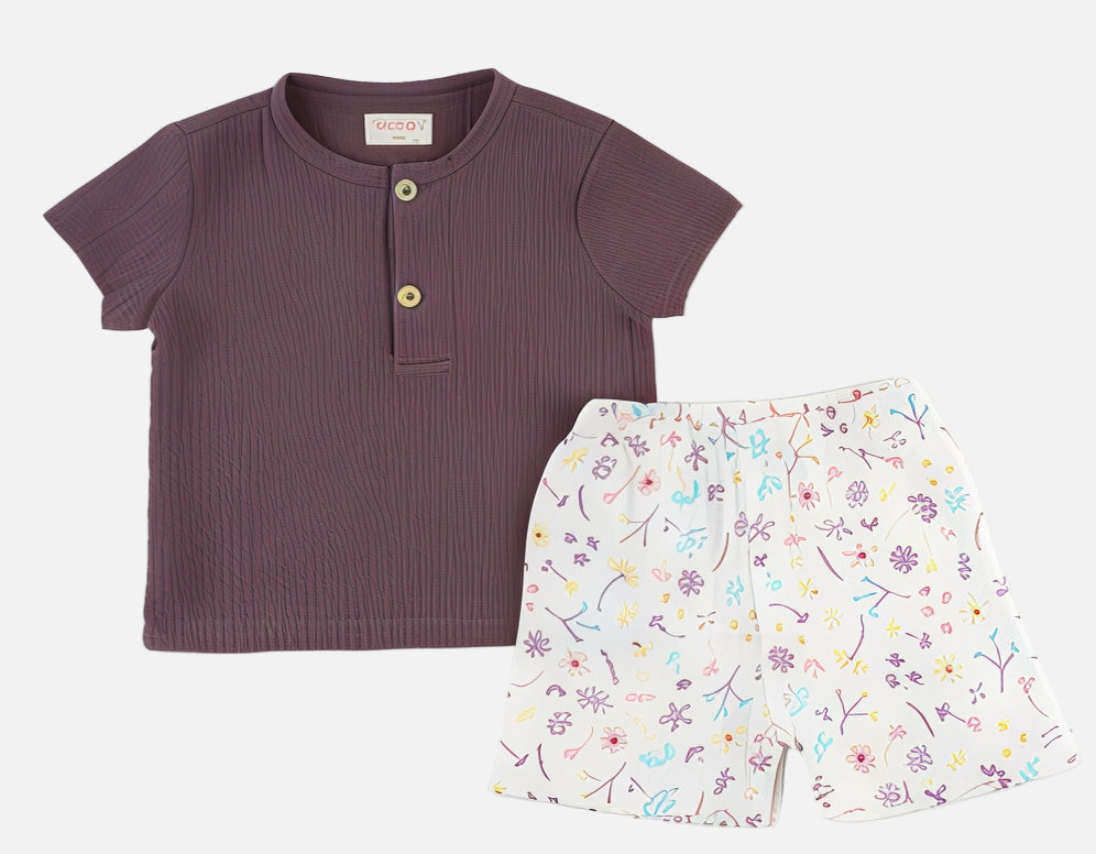Children's purple shirt and floral shorts on a white background
