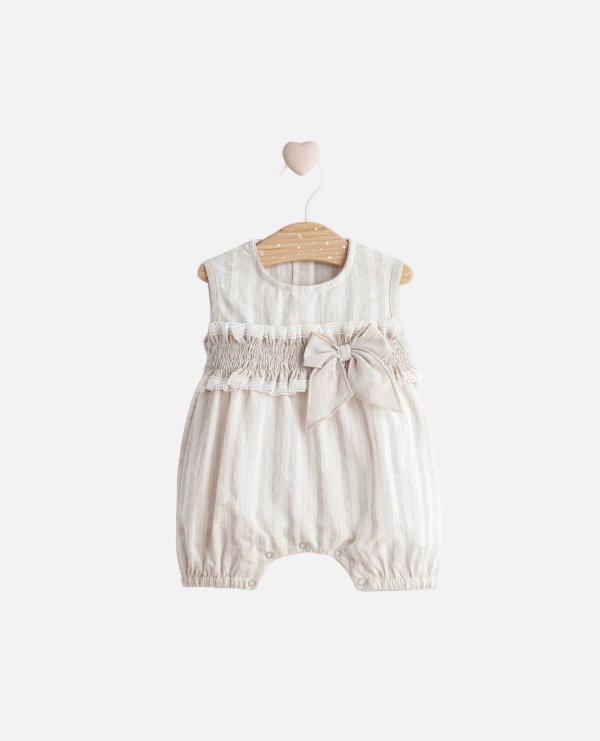 Baby romper with bow detail on a hanger against a light background