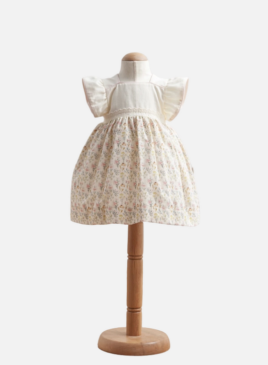 White lace dress on a mannequin with a wooden base against a white background