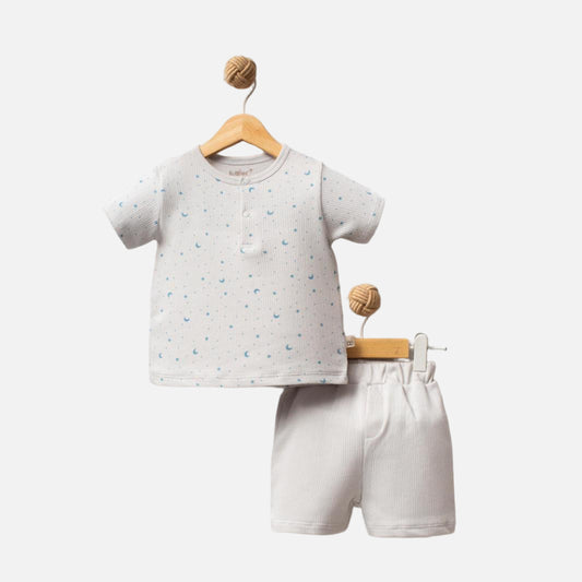 Children's outfit with a gray shirt and white shorts on wooden hangers against a light background, branded 'Shiny Moon'.