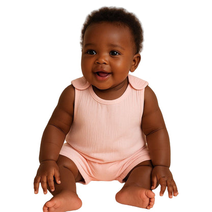 Baby wearing a pink sleeveless dress sitting on a beige background
