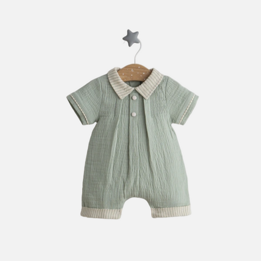 Green baby romper with white collar on a gray background