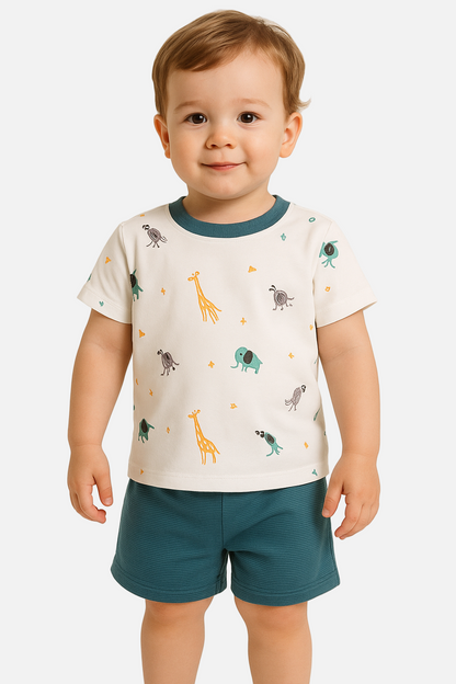 Child wearing a white t-shirt with animal prints and teal shorts on a beige background