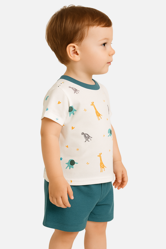 Child wearing a white t-shirt with animal prints and teal shorts on a beige background