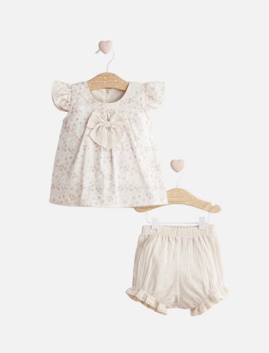 Baby outfit with floral top and shorts on a white background